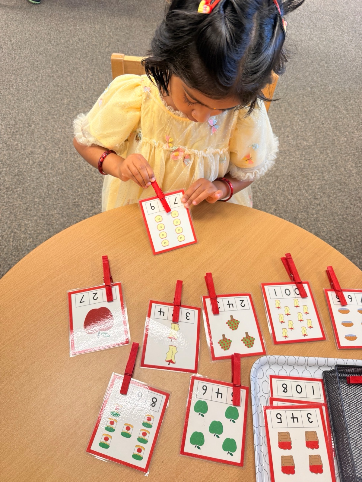 child matching quantities with clothespin cards