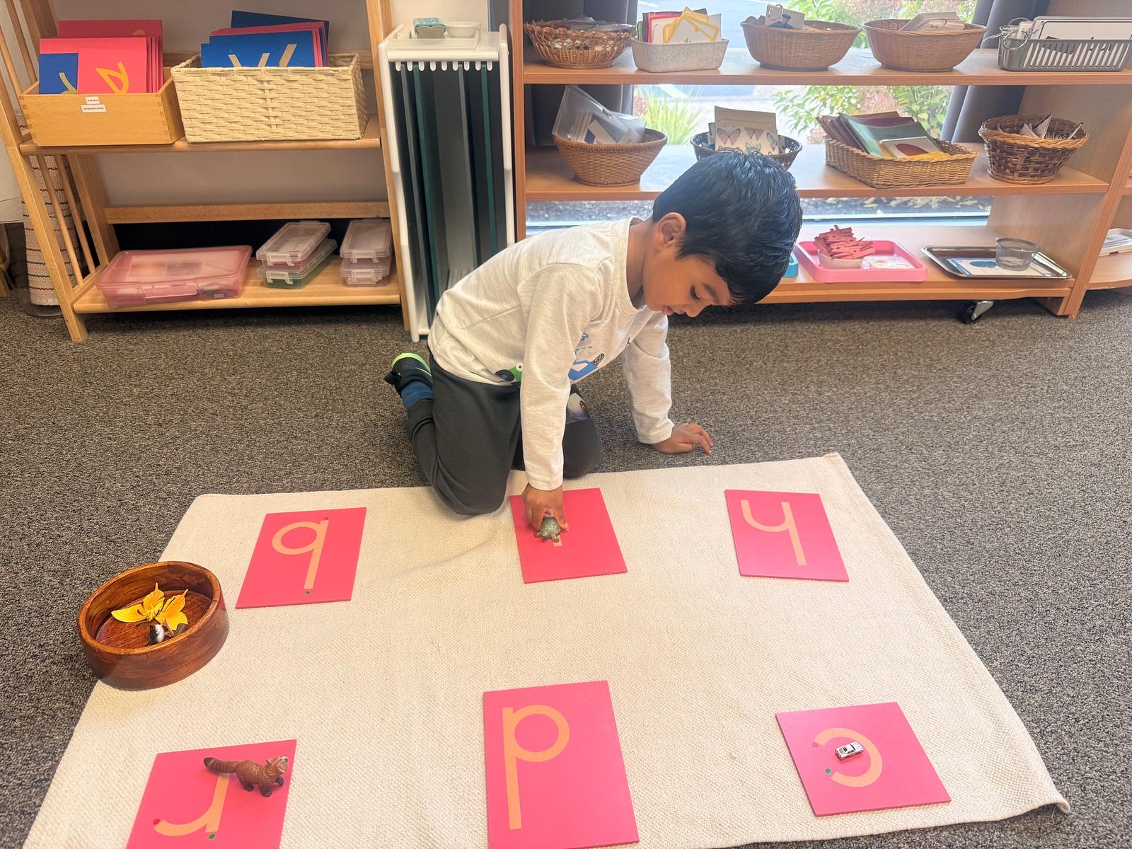 child working with sandpaper letters and objects