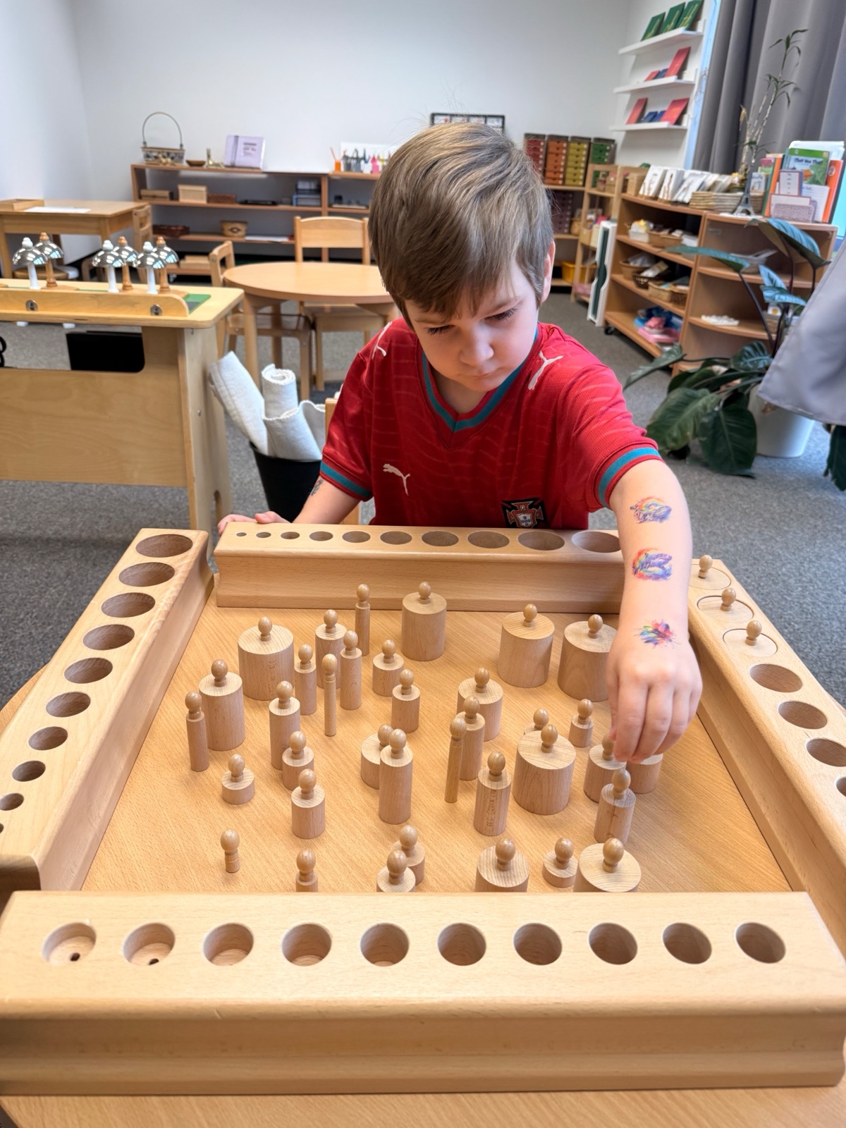 Primary child working with the knobbed cylinders