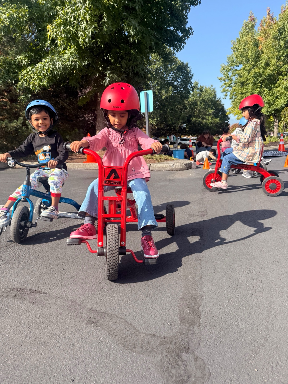 children riding tricycles together outside