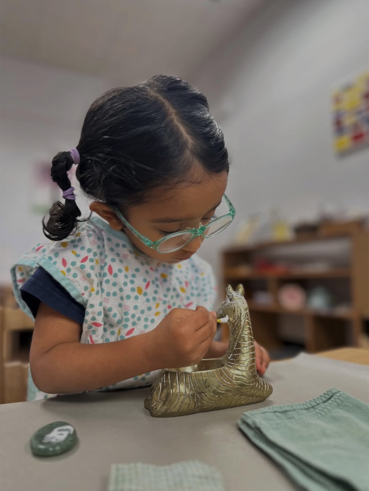 child polishing brass, deep concentration and care of the environment